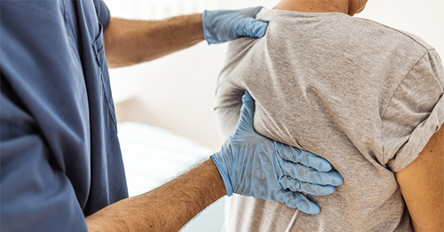 A doctor examining a woman's back.