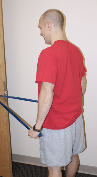 Man standing holding an arm band with arms straight down.